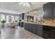 Well-lit open concept kitchen with granite countertops, dark cabinetry, and stainless steel appliances at 1433 Janice Sw Ct, Lilburn, GA 30047