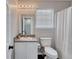 Well-lit bathroom with a granite-look vanity and shower featuring a shower curtain and window at 217 Odyssey Turn, Conyers, GA 30012