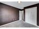 Cozy bedroom featuring a neutral carpet, dark walls, and a spacious closet at 217 Odyssey Turn, Conyers, GA 30012