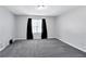 Bedroom with carpet, neutral walls, black curtains and large window at 217 Odyssey Turn, Conyers, GA 30012