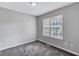 Bedroom featuring carpeted floors, grey walls, and a window with blinds for natural light at 217 Odyssey Turn, Conyers, GA 30012