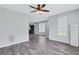 Spacious living room featuring wood-look floors, a modern ceiling fan, and natural light from a window at 217 Odyssey Turn, Conyers, GA 30012
