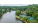 Scenic aerial view of a lake surrounded by lush trees with the tennis courts and clubhouse nearby at 434 Teal Ct, Roswell, GA 30076