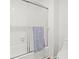 Bright bathroom featuring a white tiled shower with a sliding door and a plush gray towel at 434 Teal Ct, Roswell, GA 30076