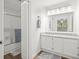 Well-lit bathroom with granite countertop, large mirror, white cabinetry, and shower with glass doors at 434 Teal Ct, Roswell, GA 30076