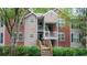 Charming condo featuring a brick and siding exterior, a wooden porch, and lush landscaping at 434 Teal Ct, Roswell, GA 30076
