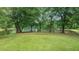 Inviting lakeside lawn with mature trees, park benches and serene water views for relaxation and recreation at 434 Teal Ct, Roswell, GA 30076