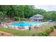 Community pool featuring a swimming area, lounge chairs, umbrellas, and landscaping at 434 Teal Ct, Roswell, GA 30076