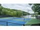 Lit tennis courts with lake view, showcasing a community amenity for active residents at 434 Teal Ct, Roswell, GA 30076