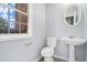 Powder room featuring a pedestal sink and a window allowing natural light at 4438 Parmalee Path, Conley, GA 30288