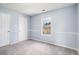 Bedroom with neutral carpet, light blue walls, two closets, and a window at 4438 Parmalee Path, Conley, GA 30288