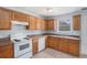 Traditional kitchen with wood cabinets, white appliances, and a double stainless steel sink at 4438 Parmalee Path, Conley, GA 30288