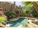 Spacious backyard with outdoor fireplace, lush greenery, and a refreshing pool area at 5284 Vernon Springs Nw Trl, Sandy Springs, GA 30327