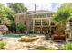 Expansive backyard featuring a pool with a waterfall, stone patio, outdoor fireplace, and a multi-level deck at 5284 Vernon Springs Nw Trl, Sandy Springs, GA 30327