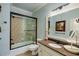 Elegant bathroom with granite countertop, decorative mirror, and tiled shower and tub featuring a black trim at 5284 Vernon Springs Nw Trl, Sandy Springs, GA 30327