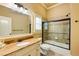 A well-lit bathroom with granite countertops, a large mirror, and shower-over-tub with glass doors at 5284 Vernon Springs Nw Trl, Sandy Springs, GA 30327