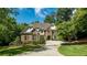 Elegant brick and stone two-story home with a manicured lawn and a circular driveway at 5284 Vernon Springs Nw Trl, Sandy Springs, GA 30327
