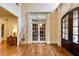Grand foyer with hardwood floors, arched doorway, and double doors leading to another room at 5284 Vernon Springs Nw Trl, Sandy Springs, GA 30327