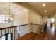 Elegant hallway with hardwood floors, chandelier, and decorative railing, leading to multiple rooms at 5284 Vernon Springs Nw Trl, Sandy Springs, GA 30327