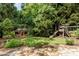 Backyard play area with a playhouse, swing set, slide and well-manicured lawn at 5284 Vernon Springs Nw Trl, Sandy Springs, GA 30327