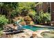 Beautiful backyard pool with a slide, waterfall, and stone patio for lounging at 5284 Vernon Springs Nw Trl, Sandy Springs, GA 30327