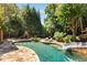 Gorgeous swimming pool area with a waterfall slide, hot tub, and stone surround at 5284 Vernon Springs Nw Trl, Sandy Springs, GA 30327