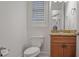 Powder room with wood cabinet, granite countertop, toilet and window at 6054 Brookhaven Cir, Duluth, GA 30097