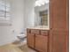 Well-lit bathroom featuring a built-in cabinet, a white toilet, and a large mirror above the sink at 6054 Brookhaven Cir, Duluth, GA 30097