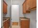 A spacious laundry room features granite countertops and ample storage with wooden cabinets at 6054 Brookhaven Cir, Duluth, GA 30097