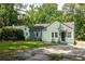 Charming one-story home with green siding, manicured lawn, and mature trees at 1170 Westmont Sw Rd, Atlanta, GA 30311