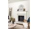 Bright living room with a fireplace, a modern sunburst mirror, and stylish decor at 1170 Westmont Sw Rd, Atlanta, GA 30311