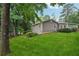 Well-maintained backyard with lush green lawn and mature trees surrounding the gray home at 2655 Nesbit Trl, Alpharetta, GA 30022