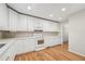 Well-lit kitchen featuring white cabinetry, modern appliances, and wood flooring at 2655 Nesbit Trl, Alpharetta, GA 30022