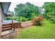 Lush backyard with grassy area and brick patio, framed by mature trees and shrubbery at 3854 Ridgewood Se Dr, Smyrna, GA 30080
