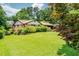 Spacious backyard featuring a well-maintained lawn, mature trees, and brick home with carport at 3854 Ridgewood Se Dr, Smyrna, GA 30080