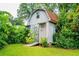 A backyard barn features gray wood siding, a barn-style door, a red roof, and green grass at 3854 Ridgewood Se Dr, Smyrna, GA 30080