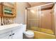 Traditional bathroom features a shower and tub combo, sink, and neutral toned striped wallpaper at 3854 Ridgewood Se Dr, Smyrna, GA 30080