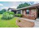 Charming brick home featuring colorful shutters, mature landscaping, and a well-maintained lawn at 3854 Ridgewood Se Dr, Smyrna, GA 30080