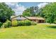 Charming one-story brick home with a well-manicured front lawn, mature trees, and covered carport at 3854 Ridgewood Se Dr, Smyrna, GA 30080