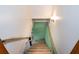 Stairwell leads to basement with neutral walls and floors and a painted green brick wall at 3854 Ridgewood Se Dr, Smyrna, GA 30080