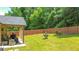 Beautiful backyard features lush lawn, covered patio, and wooden privacy fence, creating a serene outdoor space at 4220 Sawgrass Dr, Lithonia, GA 30038