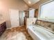 This bathroom has tile flooring, a soaking tub, glass shower, and a single sink vanity at 4220 Sawgrass Dr, Lithonia, GA 30038