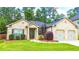 Well-maintained brick home with a green lawn, landscaping, and a two-car garage at 4220 Sawgrass Dr, Lithonia, GA 30038
