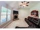 This living room features carpet flooring, a ceiling fan, a brick fireplace, and a large window at 4220 Sawgrass Dr, Lithonia, GA 30038