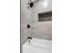 Stylish shower with gray tiling, recessed shelving, and a modern shower head at 4800 Countryside E, Stone Mountain, GA 30083