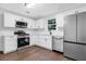 Bright kitchen featuring stainless appliances, white cabinets, quartz countertops, and hardwood flooring at 4800 Countryside E, Stone Mountain, GA 30083