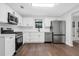Bright kitchen featuring stainless appliances, white cabinets, quartz countertops, and hardwood flooring at 4800 Countryside E, Stone Mountain, GA 30083