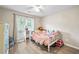 Bedroom features a toddler bed, window and wood flooring plus soft lighting and decorations at 7720 Paddocks Mill Dr, Cumming, GA 30041