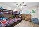 This bedroom features a bunk bed, two dressers, a ceiling fan and wood flooring with plenty of space at 7720 Paddocks Mill Dr, Cumming, GA 30041