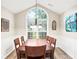 This dining room features a vaulted ceiling, large window and wood flooring, with seating for six at the dining table at 7720 Paddocks Mill Dr, Cumming, GA 30041